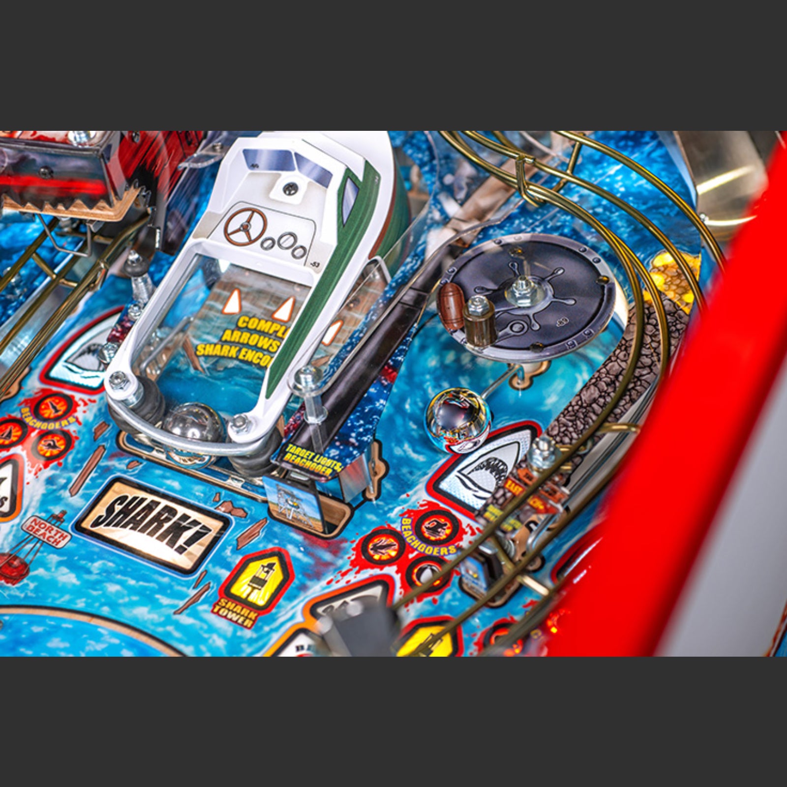 Nitro Pinball Sales Jaws 50th Annyversary Close-up of a pinball machine with colorful design and various components.