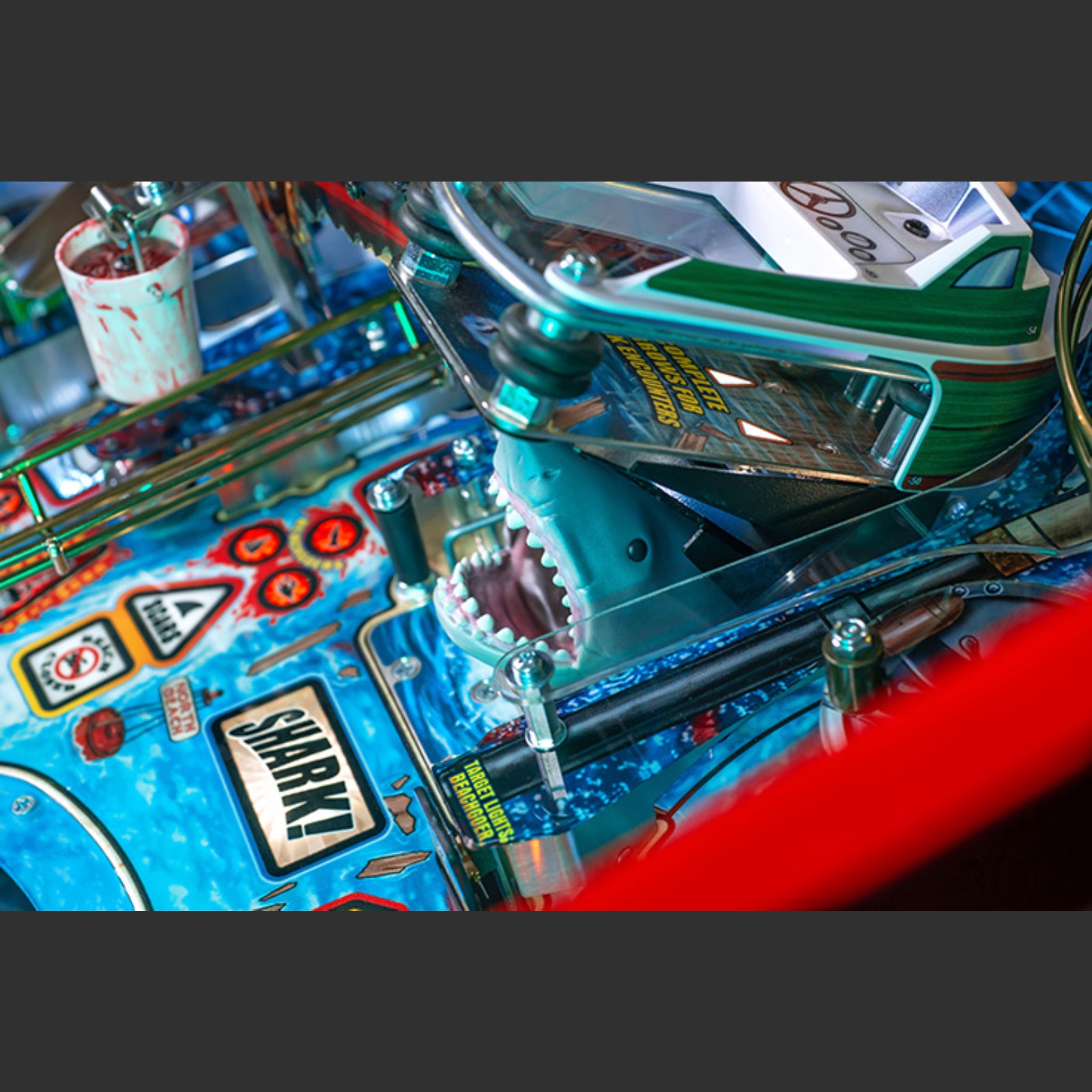 Nitro Pinball Sales Jaws 50th Annyversary Close-up of a pinball machine with 'Shark' label and colorful design.